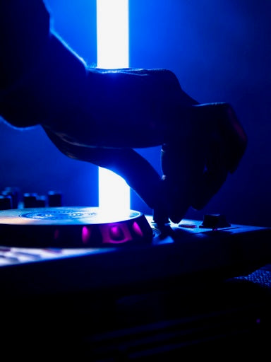 Vance LaRoy using a turntable in a dark setting with blue lighting